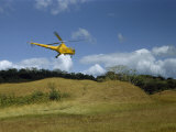 Buy Yellow Helicopter Hovers over a Mound of an Archeological Site at AllPosters.com