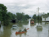 Buy Men Paddle Canoe Down Street Submerged by Flash Flood in May 1951 at AllPosters.com