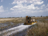 Men Drive an Air Boat over Grassy Shallows Photographic Print