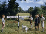 Boys and a Dog Stand by a Signpost Inscribed with the Names of Towns