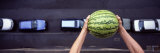 Person Dropping a Watermelon from High Above onto a Street