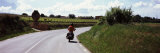 Man Riding a Motorcycle on a Road with Vineyards in the Background, Penedes, Catalonia, Spain