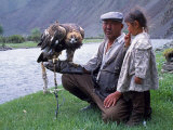 Mongolia, Kasakh Hunter with Eagle by the Khovd River, with a Small Child