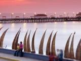 Waterfront Scene at Huanchaco in Peru, Locals Relax Next to Totora Boats Stacked Along the Beach