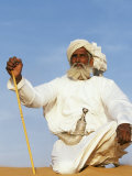 Bedouin Man Kneels on Top of a Sand Dune in the Desert