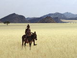 Buy Old Himba Woman, Upright Despite Her Years, Rides Her Donkey Through Harsh Land at AllPosters.com