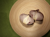 A Two One-Halfs of a Red Onion on a Wooden Plate