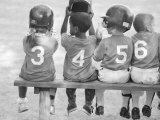 Four Young Baseball Players Wearing Sequential Numbers