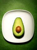 Half an Avocado on a White Plate