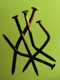 Five Rusty Nails Against a Green Background
