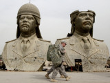 US Soldiers Stroll Past Bronze Busts of Former Iraqi President Saddam Hussein in Baghdad