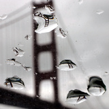 Rain Drops are Shown on a Car Windshield with the Golden Gate Bridge in Background