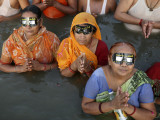 Hindu Devotees Observe a Solar Eclipse as They Take Holy Dips in the Sangam in Allahabad, India