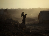 Displaced Man Holds His Baby Next to His Tent in Jalozai Refugee Camp Near Peshawar, Pakistan