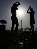 Indian Cycle Rickshaw Pullers Bathe by the Road Side on World Water Day in Allahabad, India