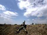 US Army Soldier Takes Cover as He Gets Ready to Search an Open Field in a Baghdad Neighborhood