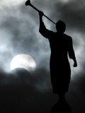 Statue is Seen Against a Cloudy Sky and a Partial Solar Eclipse in Bogota, Colombia