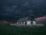 Old Barn Stands in a Wheat Field as a Thunderstorm Passes in the Distance Near Ogallah, Kansas