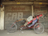 Indian Rickshaw Puller Rests in the Shade at a Closed Market Complex in New Delhi, India