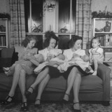 Women Bottle-Feeding their Babies at Christmas Family Reunion Celebration