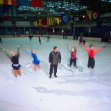 Quartet of Leaping Young Girl Skaters Urged by Coach During Freestyle Routine Practice at Sky Rink Premium Photographic Print
