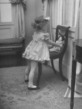Little Girl Wearing Kate Greenway Fashions Sitting Her Doll in a Chair