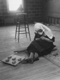 Nun Sitting on Floor and Making Clay Sculptures
