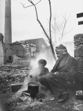 Refugee Woman and Man Sitting Outside Cooking