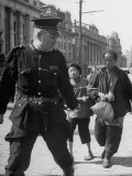 Police Officer Leading Arrested Thieves with Rope