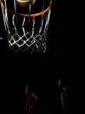Two Young Men Playing Basketball (Focus on Hoop in Foreground)