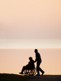 Man Pushing His Senior Mother in a Wheelchair Near Seashore, Motala, Sweden