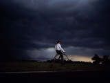 Buy A Cyclist on a 19Th-Century Bicycle Pedals Ahead of a Thunderstorm at AllPosters.com