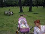A Mother Smiles at Her Baby Sleeping in a Carriage in Tauride Garden