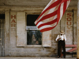A Man Eating on the Front Porch of an Old Store