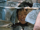 Buy A Young Girl Looks Through Prayer Flags in the Sichuan Province at AllPosters.com