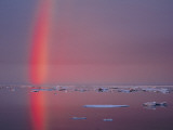 Buy A Beautiful Rainbow Rises from its Reflection on the Icy Arctic Ocean at AllPosters.com