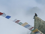 Mountain Climber Alex Lowe Sits on a Rock Near Tibetan Prayer Flags