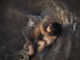 Buy Sisters Bathe in Warm, Waste-Polluted Water of the Mekong River at AllPosters.com