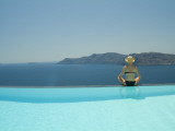 A Woman at the Edge of an Infinity Pool Overlooking the Aegean Sea
