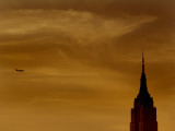 The Empire State Building and a Plane Silhouetted at Sunset