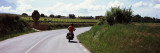 Man Riding a Motorcycle on a Road with Vineyards in the Background, Penedes, Catalonia, Spain