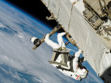 An Astronaut Mission Specialist, Crawls Along a Truss on the International Space Station