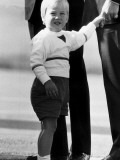 Buy Prince William grips the finger of father Prince Charles at Aberdeen airport , September 1984 at AllPosters.com