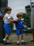 Buy Prince Harry wearing a blue sweatshirt shorts and thomas the tank engine bag with Prince William on at AllPosters.com