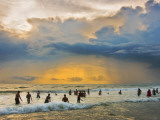 Indian Bathers Playing in Surf During Cloudy Sunset
