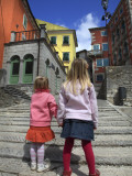 Two Girls on Ulica 1 Maja Street with Colourful Buildings
