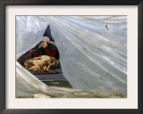 An Elderly Kosovar Woman Sits Behind a Plastic Wind Guard Around Her Spot