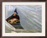 An Elderly Kosovar Woman Sits Behind a Plastic Wind Guard Around Her Spot