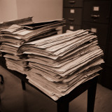 Small Table Piled High With Paper Manila Folders and Files