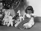 Young Girl in Pajamas, Opening Christmas Stocking Next To Christmas Tree